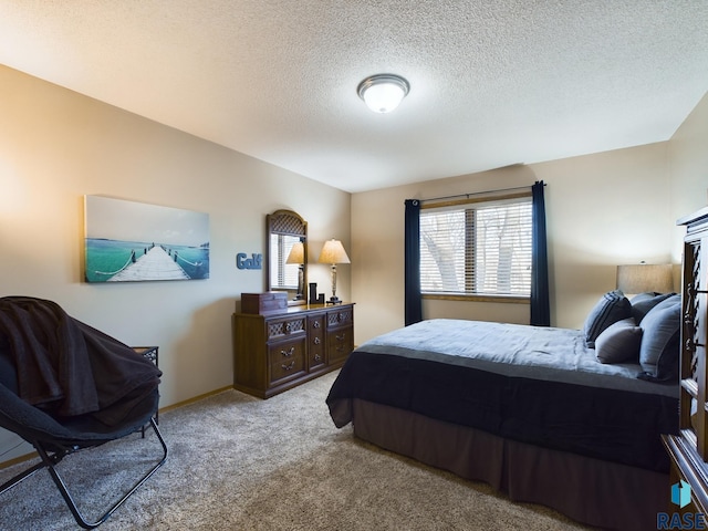 bedroom featuring light colored carpet and a textured ceiling