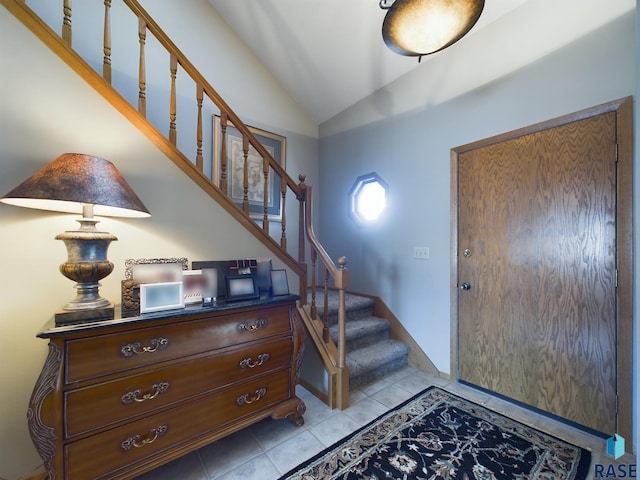 tiled foyer entrance featuring vaulted ceiling