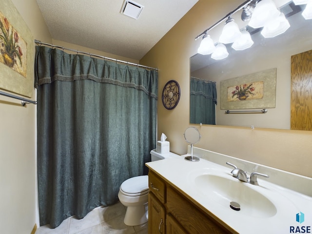 bathroom featuring tile patterned flooring, vanity, toilet, and a textured ceiling