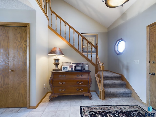 entrance foyer with lofted ceiling and light tile patterned floors