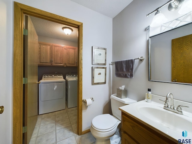 bathroom with vanity, tile patterned floors, toilet, washing machine and dryer, and a textured ceiling