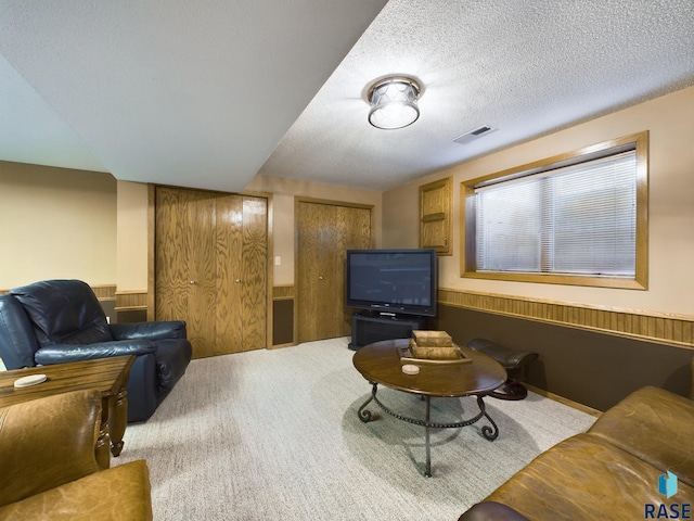 living room featuring carpet and a textured ceiling