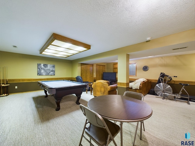 recreation room with a textured ceiling, light colored carpet, wooden walls, and billiards