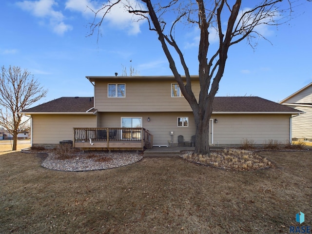 back of property featuring a lawn and a deck