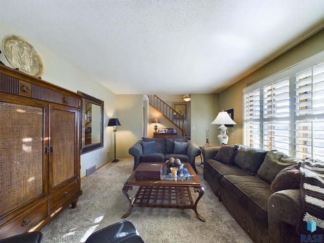 carpeted living room featuring a textured ceiling