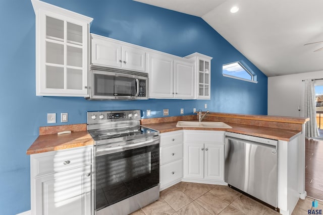 kitchen featuring sink, white cabinets, stainless steel appliances, and lofted ceiling