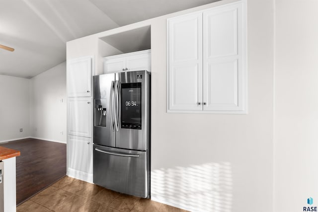 kitchen featuring stainless steel fridge, white cabinets, and dark wood-type flooring