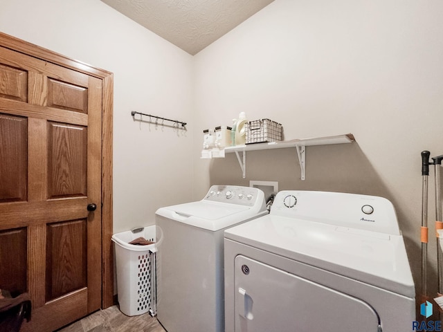 clothes washing area with a textured ceiling and independent washer and dryer