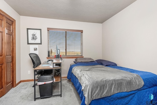 bedroom with a textured ceiling and light colored carpet