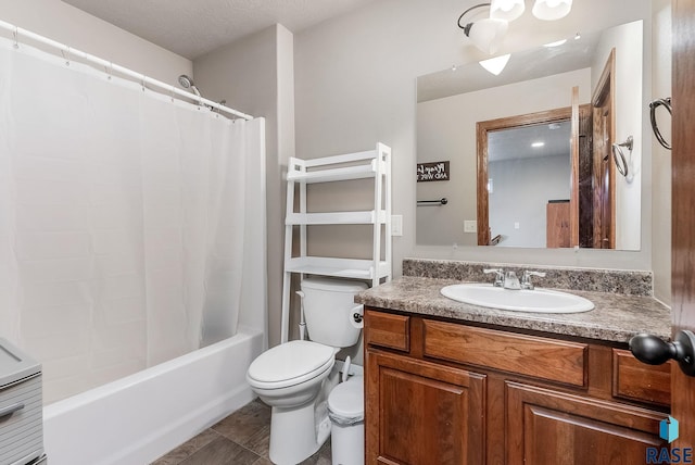 full bathroom featuring vanity, toilet, shower / bath combo with shower curtain, and a textured ceiling