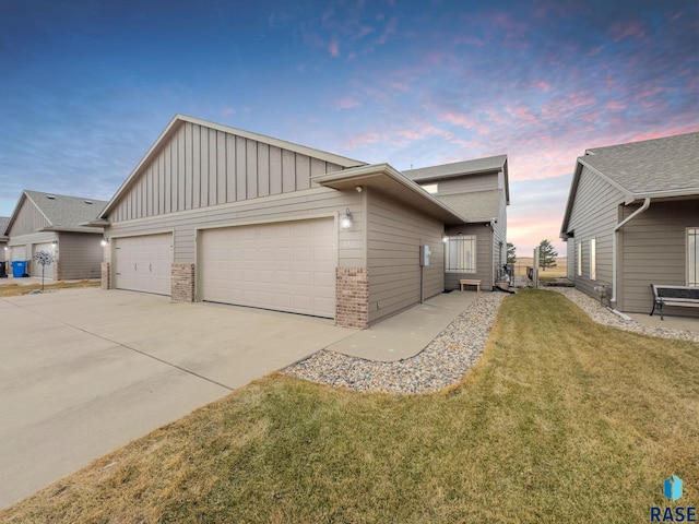 property exterior at dusk featuring a lawn and a garage