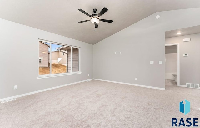 carpeted spare room featuring ceiling fan and vaulted ceiling