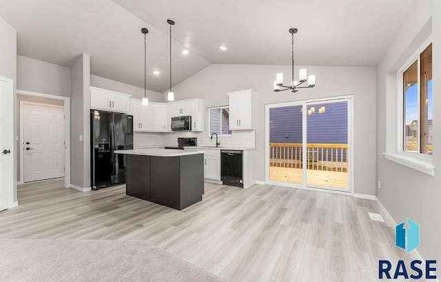 kitchen featuring black appliances, a kitchen island, white cabinets, and pendant lighting