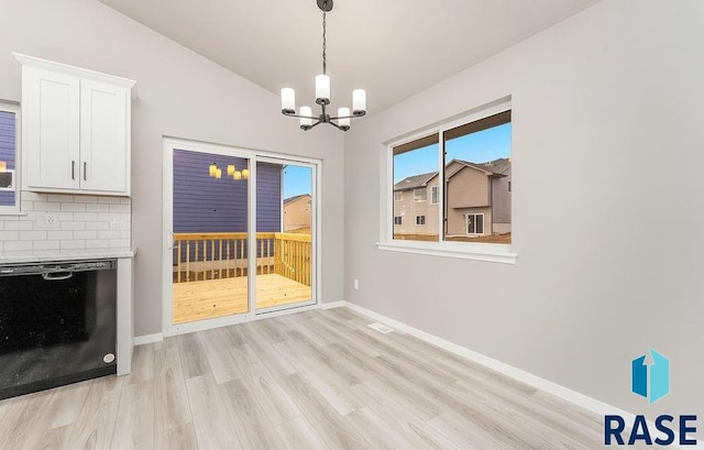 unfurnished dining area with light hardwood / wood-style floors and an inviting chandelier