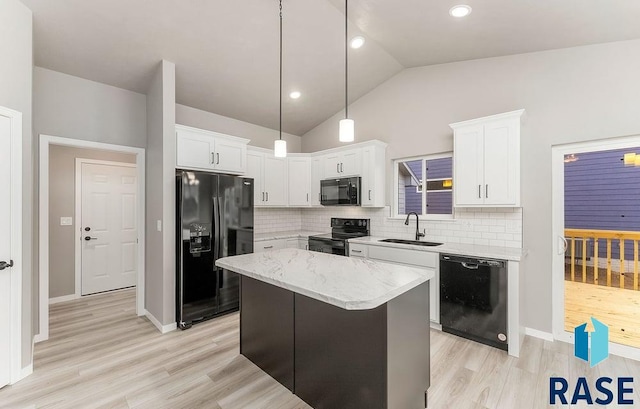 kitchen with sink, a kitchen island, tasteful backsplash, white cabinets, and black appliances