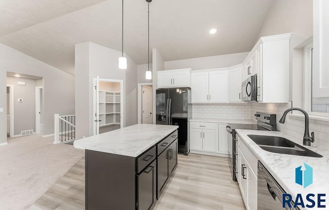 kitchen featuring white cabinets, sink, a kitchen island, and stainless steel appliances