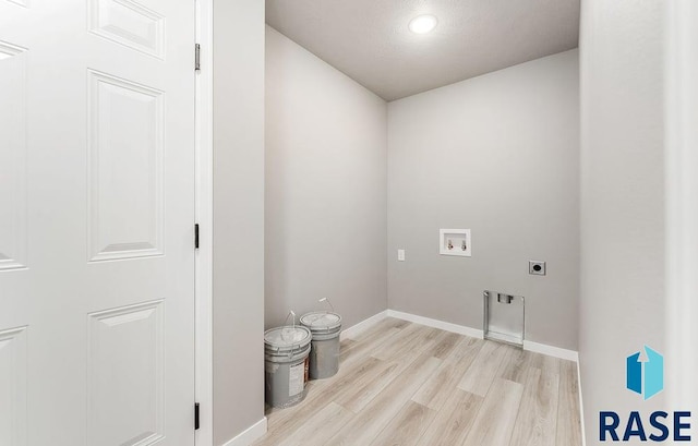 clothes washing area with electric dryer hookup, washer hookup, and light wood-type flooring