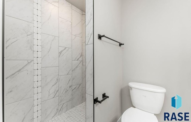 bathroom featuring toilet and tiled shower