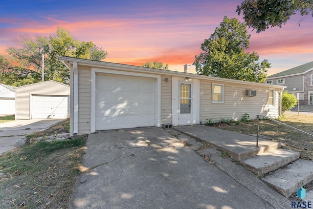 single story home featuring an outbuilding, a garage, and a wall mounted AC