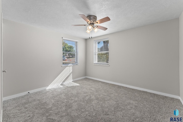 carpeted empty room featuring ceiling fan and a textured ceiling