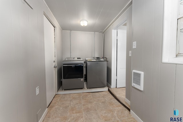 clothes washing area featuring independent washer and dryer and heating unit