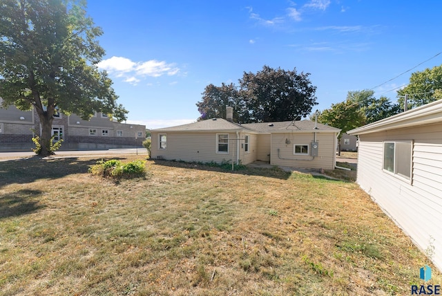 back of house with a lawn