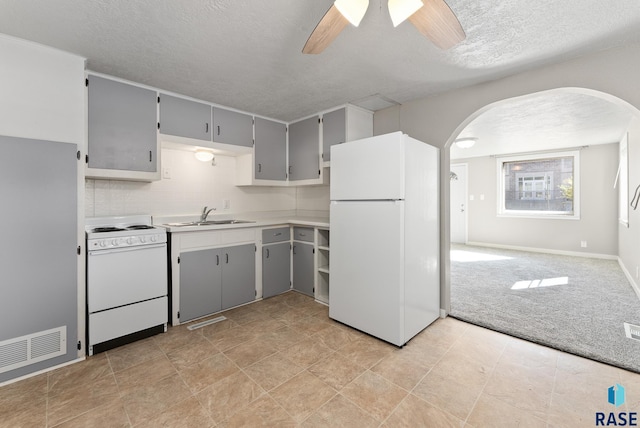 kitchen featuring white appliances, light colored carpet, ceiling fan, sink, and gray cabinets