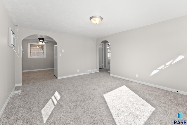 empty room with ceiling fan, light carpet, and a wall mounted AC