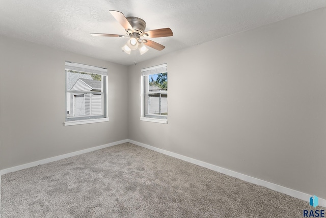 carpeted spare room with a textured ceiling and ceiling fan