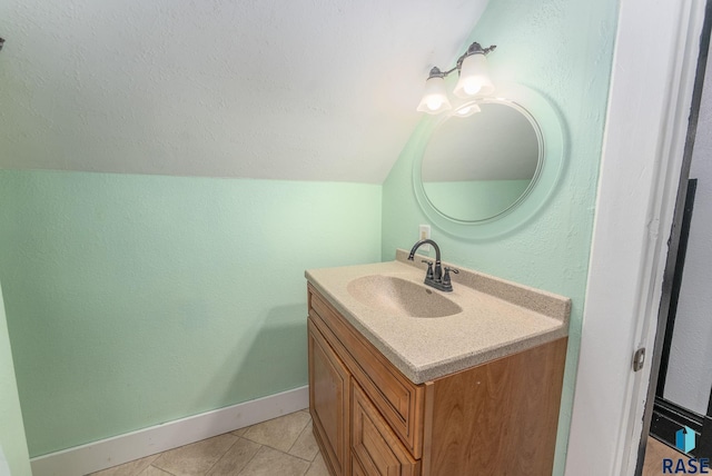 bathroom featuring tile patterned floors, vanity, and vaulted ceiling