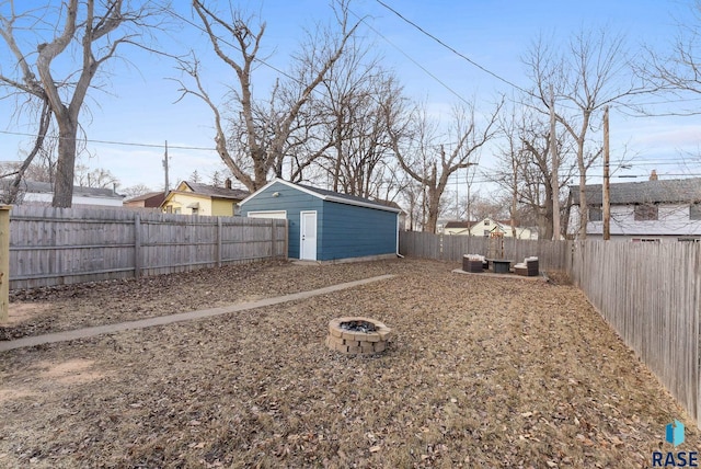 view of yard featuring an outbuilding and a fire pit