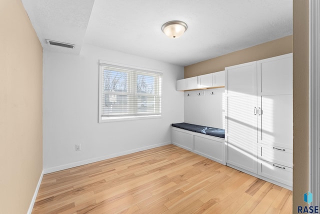 unfurnished bedroom with a textured ceiling and light wood-type flooring