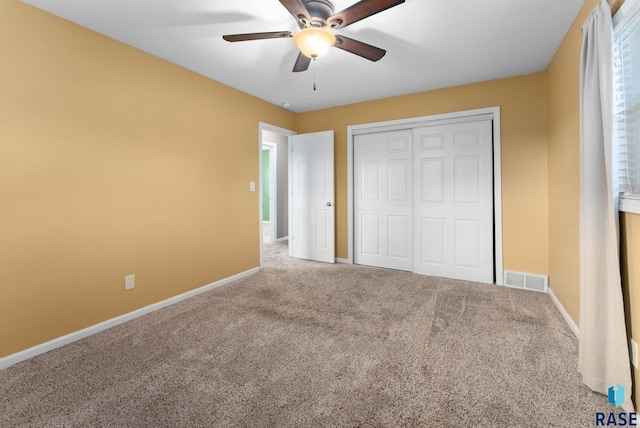 unfurnished bedroom with ceiling fan, a closet, and carpet floors