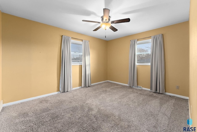 spare room featuring ceiling fan and carpet floors