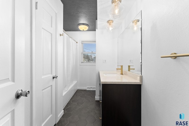 bathroom featuring tile patterned flooring, vanity, shower / bath combination with curtain, and a textured ceiling