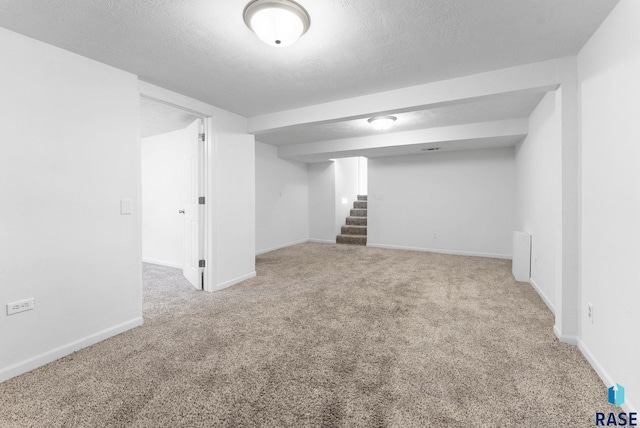 basement featuring carpet floors and a textured ceiling