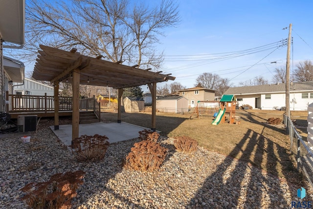 view of yard featuring a patio area, a deck, a playground, and central AC