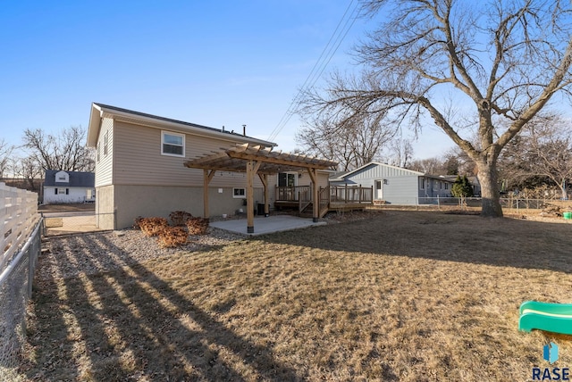 back of house featuring a lawn, a pergola, a patio, and a wooden deck