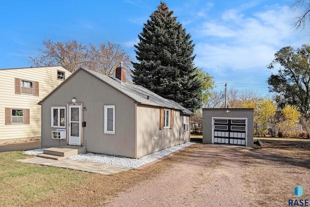 exterior space with a garage and an outbuilding