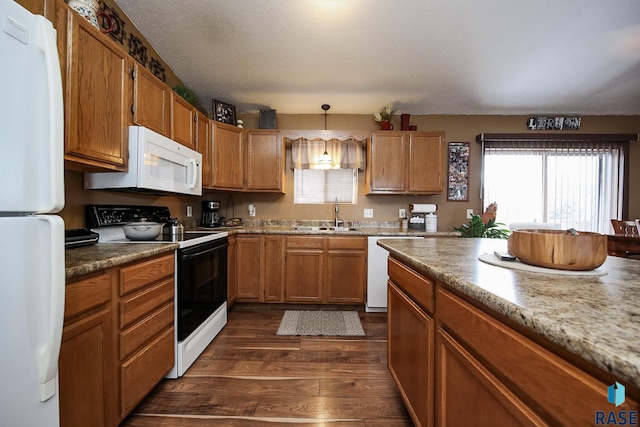 kitchen with white appliances, sink, a textured ceiling, decorative light fixtures, and dark hardwood / wood-style flooring