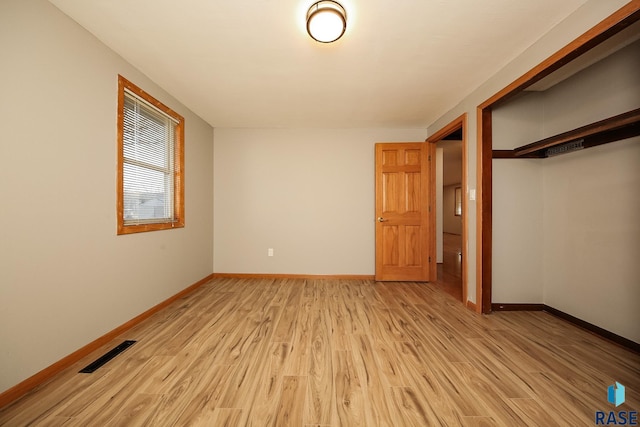 unfurnished bedroom with a closet and light wood-type flooring