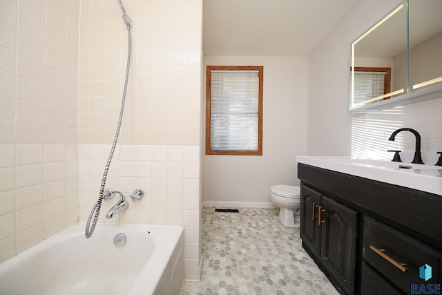 full bathroom featuring vanity, toilet, and tiled shower / bath