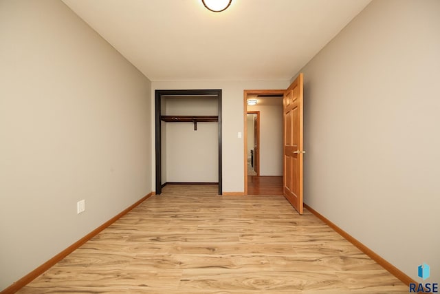 unfurnished bedroom featuring light hardwood / wood-style flooring and a closet