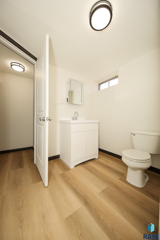 bathroom with hardwood / wood-style floors, vanity, and toilet