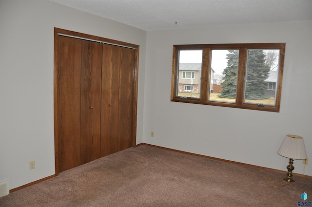 unfurnished bedroom featuring carpet floors and a closet