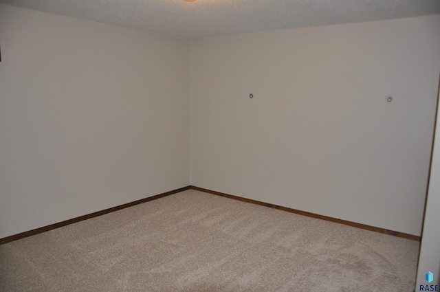 carpeted empty room featuring a textured ceiling