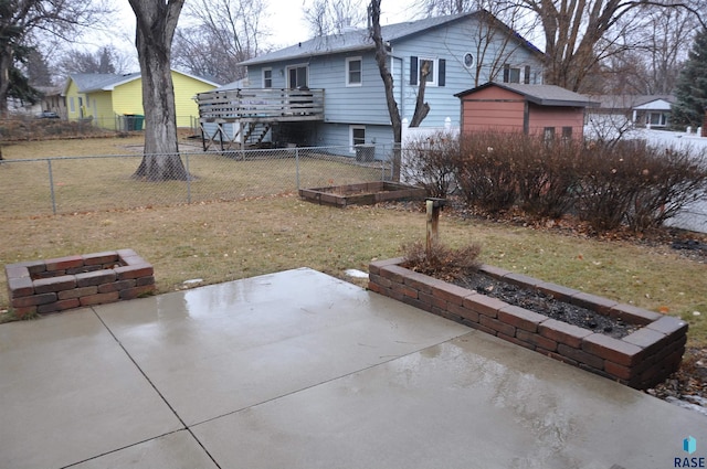 back of property with a yard, a patio, and a wooden deck