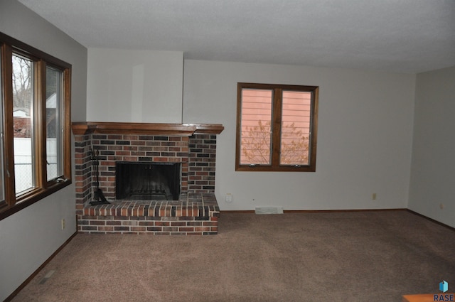 unfurnished living room with carpet and a brick fireplace