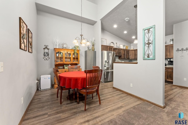 dining space featuring an inviting chandelier and vaulted ceiling