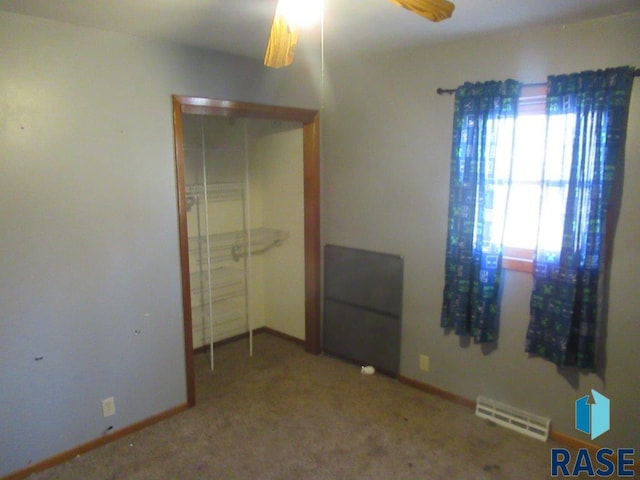 unfurnished bedroom featuring carpet flooring, ceiling fan, and a closet